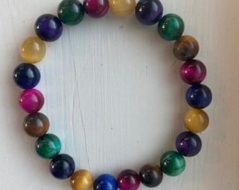 Chakra Balancing tiger’s eye bracelet with yellow, blue,green,pink, brown, and purple 8mm tiger’s eye beads. Balance-Success-Health