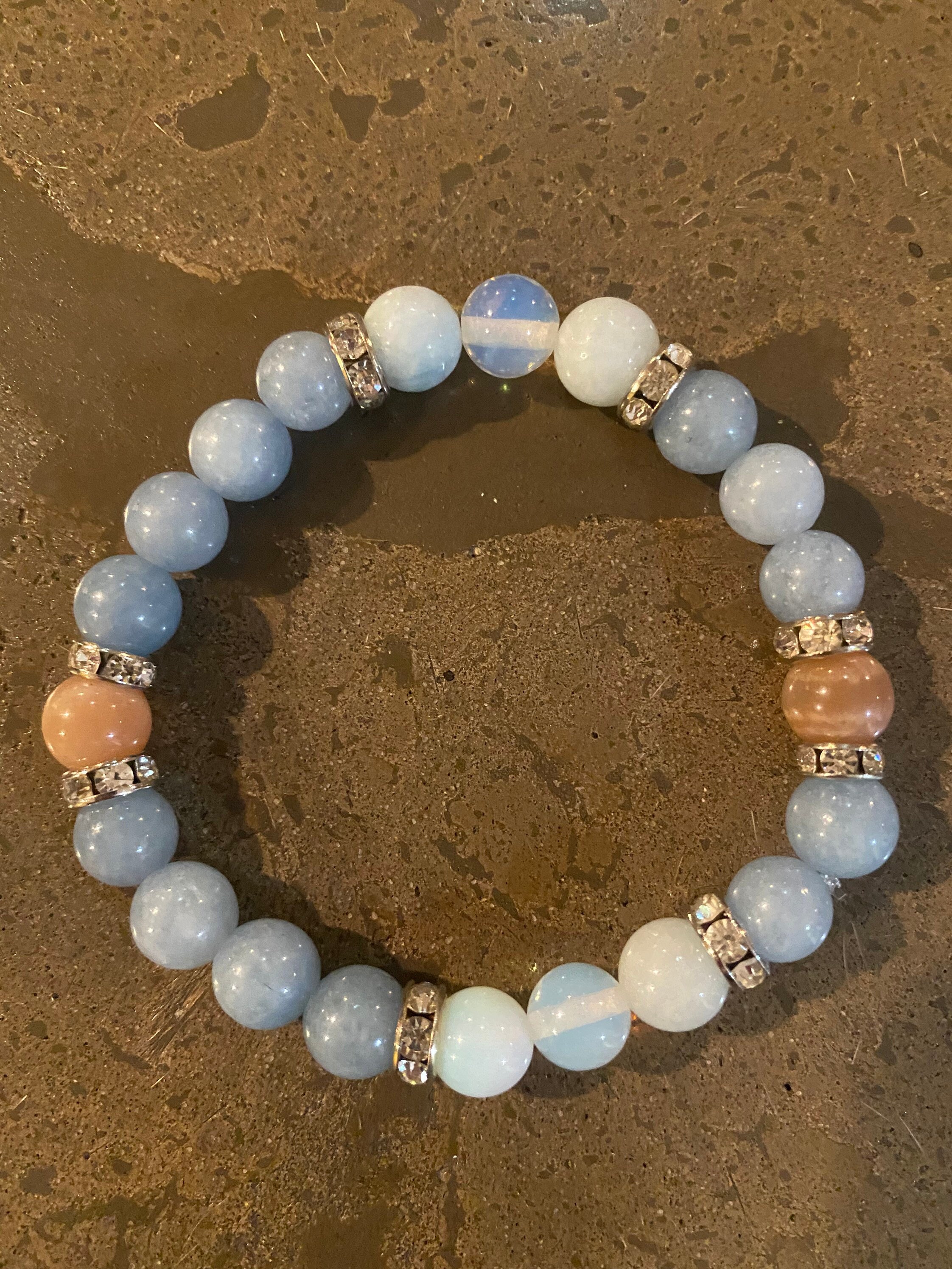 Strength and courage stretch bracelet with grade AA Opalite, aquamarine and sunstone 8mm beads. All jewelry is infused with reiki energy