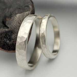 Conjunto de alianças de casamento em prata de lei martelada, estilo rústico minimalista, com acabamento escovado.