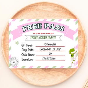 May include: A festive Free Pass card with pink and green accents. The card reads "FREE PASS" and includes fields for Elf Name, Play Date, Child Name, and Signature. A cartoon elf climbs a ladder on the right.