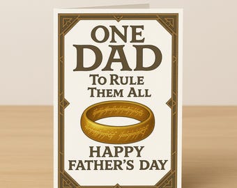 Może przedstawiać: Kartka na Dzień Ojca z ilustracją złotego pierścienia oraz napisem "ONE DAD TO RULE THEM ALL" i "HAPPY FATHER'S DAY". Kartka ma ozdobną ramkę.