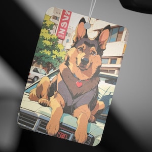 May include: A brown and black German Shepherd dog sitting on the hood of a white car. The dog is wearing a red heart-shaped charm on a silver chain. The car is parked in a city street with buildings in the background.