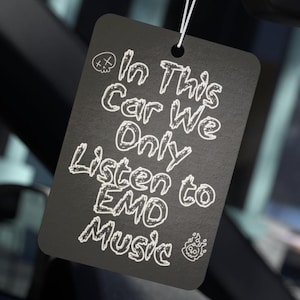 Puede incluir: Ambientador de coche rectangular negro con texto blanco: "In This Car We Only Listen to EMO Music". Tiene una cuerda para colgar y presenta un cráneo y un gráfico de llama.