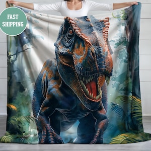 May include: A blue and orange dinosaur with a watercolor background. The dinosaur is a Tyrannosaurus Rex with a large head and sharp teeth. The background is a green and blue watercolor wash with a few leaves.