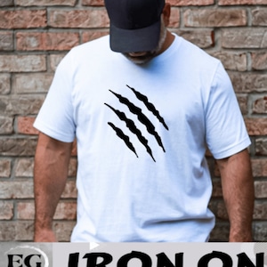 May include: White t-shirt with a black iron-on design of four claw marks. The text "IRON ON" is printed below the shirt.