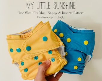May include: Two cloth diapers, one yellow and one blue, with white trim and snap closures. The diapers are folded and have a variety of colored snaps. The text "MY LITTLE SUNSHINE" and "One Size Fits Most Nappy & Inserts Pattern" is visible above the diapers. The text "Fits from approx. 4-17kg" is visible below the diapers.
