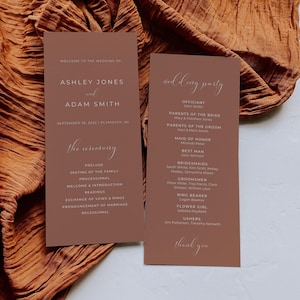 May include: Two brown cards with white text announcing a wedding ceremony for Ashley Jones and Adam Smith on September 18, 2022 in Plymouth, MI. The first card lists the order of the ceremony. The second card lists the wedding party, including the officiant, parents of the bride and groom, maid of honor, best man, bridesmaids, groomsmen, ring bearer, flower girl, and ushers.