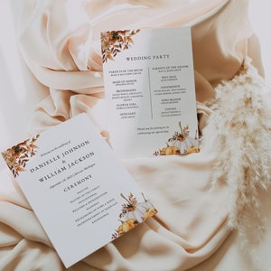 May include: Wedding ceremony program with a fall theme. The program features a watercolor illustration of pumpkins, leaves, and flowers. The text includes the names of the bride and groom, Danielle Johnson and William Jackson, the date of the wedding, September 18, 2023, and the location, Detroit, Michigan. The program also includes a list of the wedding party members and the order of the ceremony.