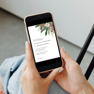 Puede incluir: Un tel&eacute;fono inteligente muestra una invitaci&oacute;n de boda. La invitaci&oacute;n presenta los nombres de Danielle Thompson & William Jackson, con texto y un borde decorativo de pi&ntilde;as y vegetaci&oacute;n. El tel&eacute;fono se sostiene con dos manos.