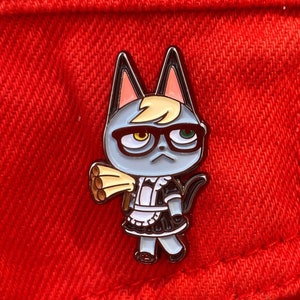 May include: Enamel pin featuring a cartoon cat character with glasses, a maid outfit, and a stern expression. The cat is gray with tan accents and wears a black and white maid uniform. The pin is set against a red background.