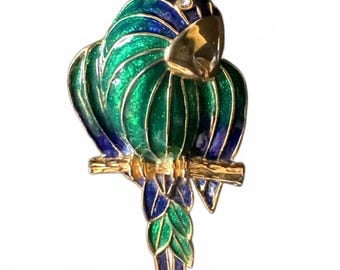 Broche perroquet en émail bleu et vert sur perchoir en émail bleu et oeillet en strass