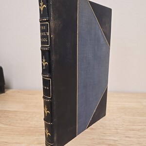 May include: A black leather-bound book with gold lettering on the spine. The title is "The Devil's Pool" by "A.E.W. Mason".