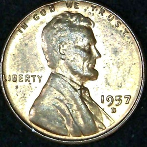 Op de afbeelding: Een koperkleurige Amerikaanse penny uit 1957 met de woorden "In God We Trust" en "Liberty" gegraveerd rond de rand. De voorzijde van de munt toont een profiel van Abraham Lincoln met het jaar "1957" en de letter "D" eronder.