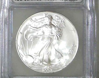 Könnte beinhalten: Eine silberne American Eagle-Münze, die von ICG mit MS70 bewertet wurde und als die 3139. von 14.987 First Day of Issue-Münzen zertifiziert ist. Die Münze zeigt eine Darstellung von Lady Liberty, die mit einer Fackel und einem Olivenzweig geht.