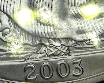 Könnte beinhalten: Nahaufnahme einer silbernen US-Viertel-Dollar-Münze mit dem Jahr 2003 auf der Unterseite.