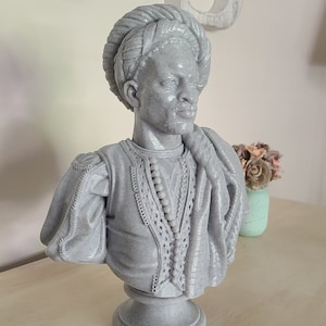 K&ouml;nnte beinhalten: Eine graue 3D-gedruckte B&uuml;ste einer Person mit Turban und verzierter Kleidung. Die B&uuml;ste steht auf einem grauen Sockel.