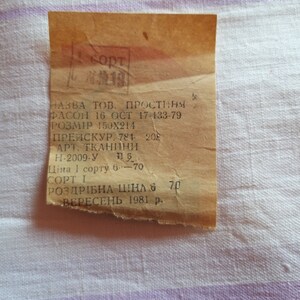 May include: A vintage price tag for a sheet, labelled "PROSTYNIA" (sheet in Polish), with the size 150x214 cm, the price 70 kopecks, and the date September 1981.