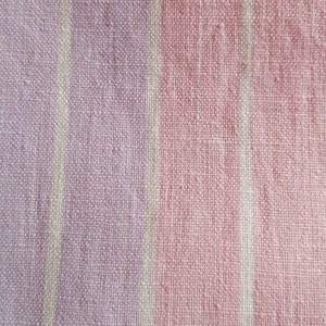 May include: Close-up of a pink and white striped fabric with a textured weave.
