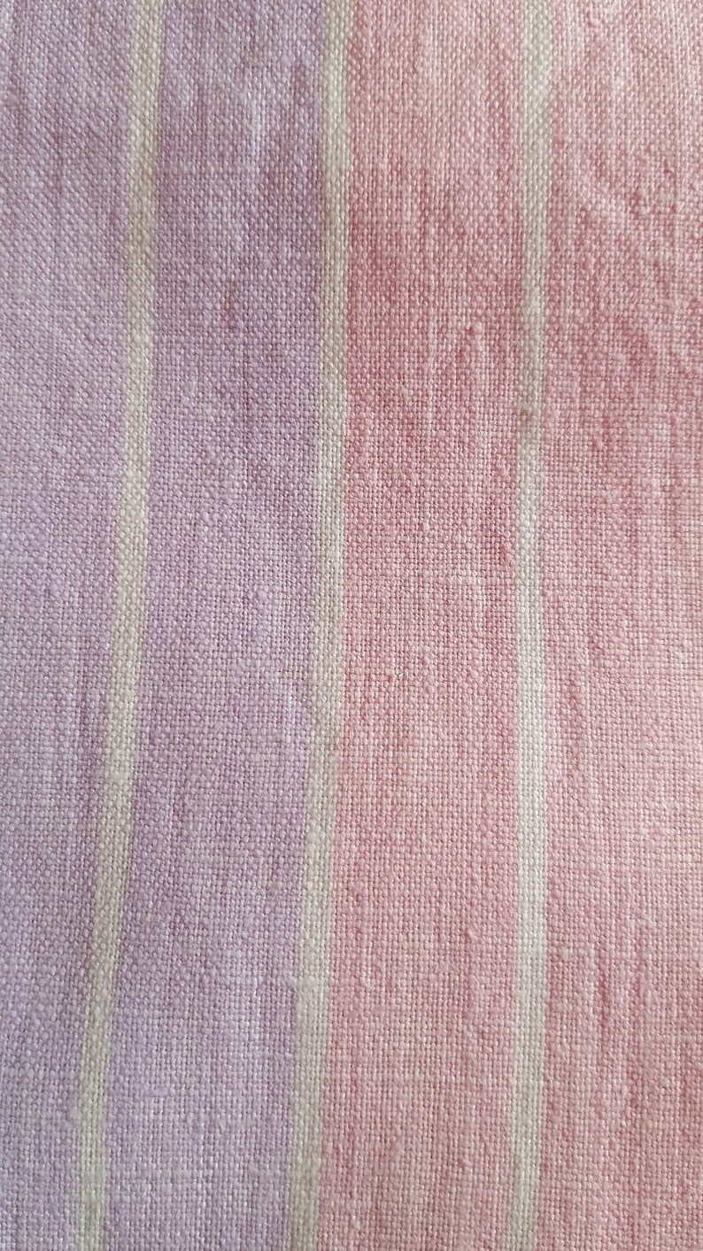 May include: Close-up of a pink and white striped fabric with a textured weave.