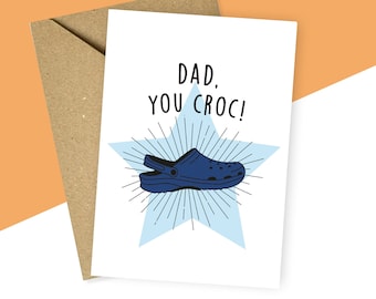 Könnte beinhalten: Eine Grußkarte mit einem blauen und weißen Sternmuster. Die Karte sagt "Papa, du Croc!" und zeigt eine blaue Cartoon-Illustration eines Clogs.