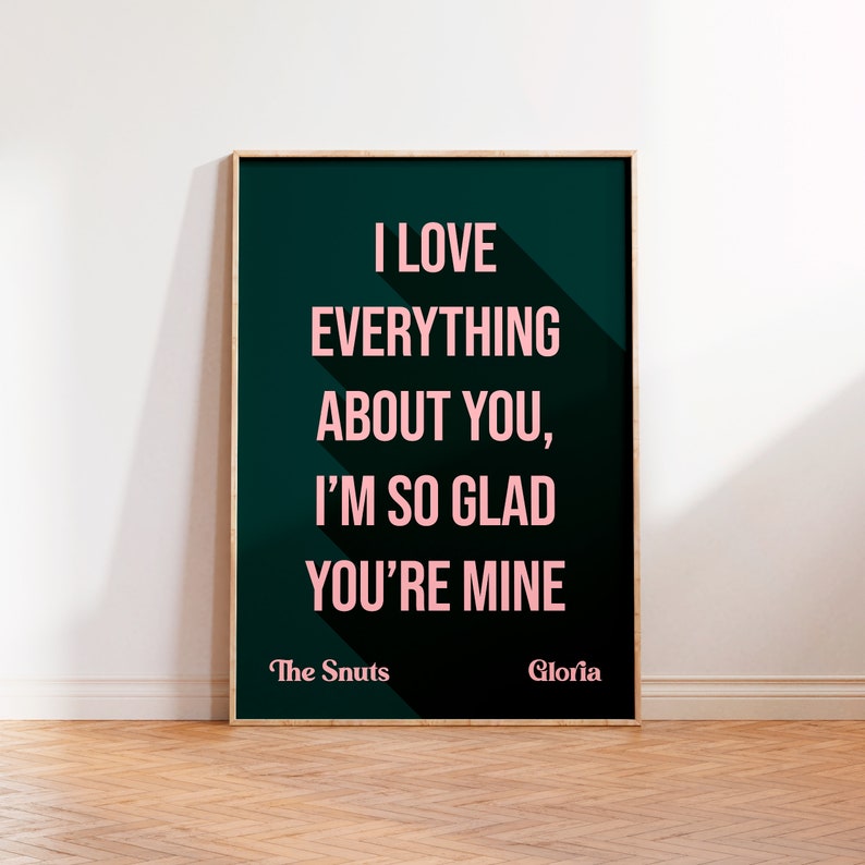 May include: A dark green poster with white text that reads "I love everything about you, I'm so glad you're mine." The text is in a pink font. The poster also includes the text "The Snuts" and "Gloria" in a smaller font at the bottom.