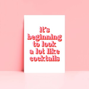 May include: A white card with pink text that reads "it's beginning to look a lot like cocktails".