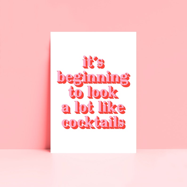 May include: A white card with pink text that reads "it's beginning to look a lot like cocktails".