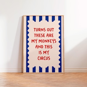 May include: A framed print with a blue and white striped border and a pink background. The text on the print reads "Turns out these are my monkeys and this is my circus" in red.