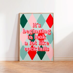 May include: A colorful poster with a diamond pattern in shades of pink, green, and red. The text "it's beginning to look a lot like cocktails" is written in pink letters.