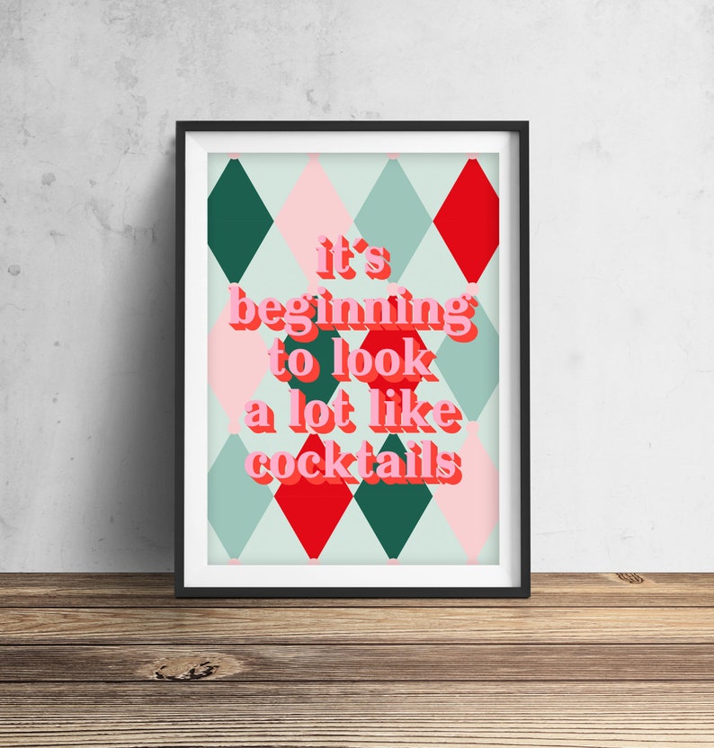 May include: A framed print with a green, red, and pink diamond pattern background. The text "it's beginning to look a lot like cocktails" is written in pink and red letters.