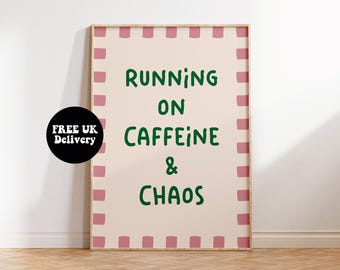 May include: A framed poster with the text "RUNNING ON CAFFEINE & CHAOS" in green lettering. The poster has a light pink background with a pink square border. A black circle with white text that says "FREE UK Delivery" is on the left side.