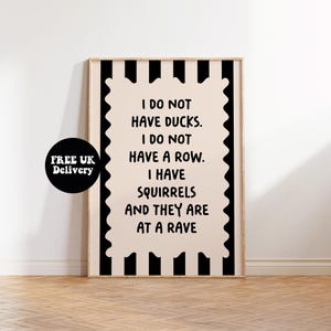 Puede incluir: Un cuadro enmarcado con fondo crema y texto negro: "I DO NOT HAVE DUCKS. I DO NOT HAVE A ROW. I HAVE SQUIRRELS AND THEY ARE AT A RAVE." El marco tiene un borde a rayas blanco y negro. Un círculo negro dice "FREE UK Delivery."