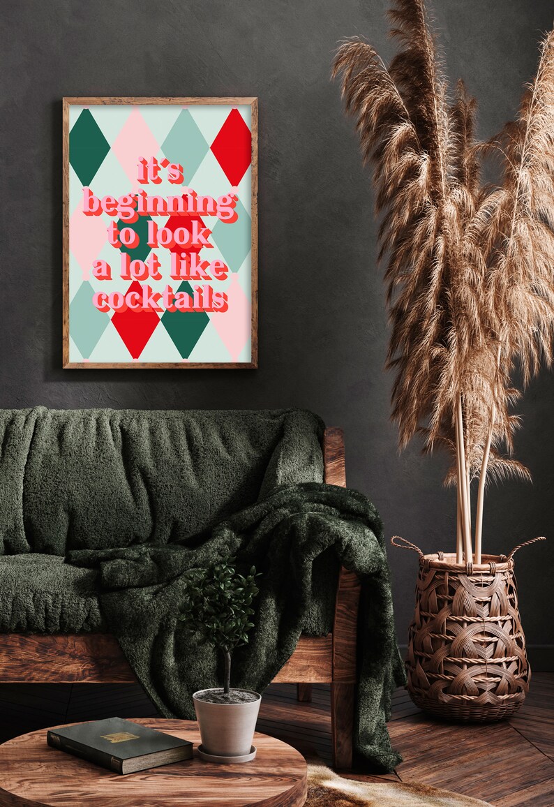 May include: A framed print with a green, red, and pink diamond pattern. The text on the print reads "It's beginning to look a lot like cocktails."