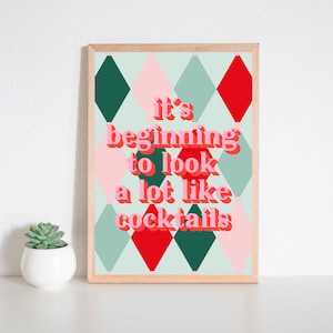 May include: A framed print with a green, red, and pink diamond pattern. The text "it's beginning to look a lot like cocktails" is written in pink letters.