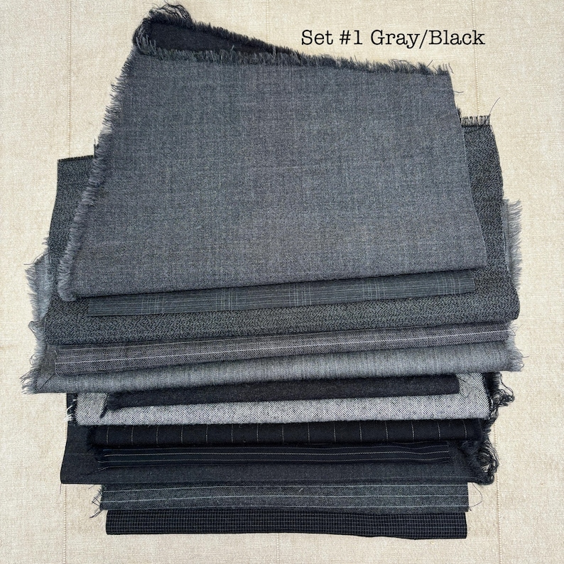 May include: A stack of gray and black fabric swatches with frayed edges. The fabrics vary in texture and pattern, including solid, plaid, and pinstripe designs. The text "Set #1 Gray/Black" is visible at the top.