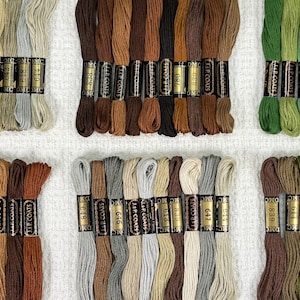 May include: Assortment of DMC embroidery floss spools in various shades of brown, green, and beige. Each spool is labeled with the DMC color number and "DMC Cotton Embroidery Floss".