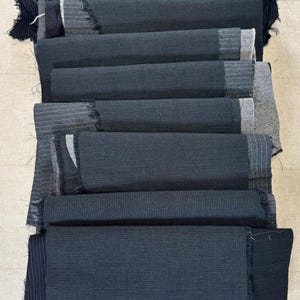 May include: A stack of fabric swatches in various shades of gray and black. The swatches are layered, with some showing a textured weave and others a striped pattern. The text "Set #1 Gray Black" is visible in the upper left corner.