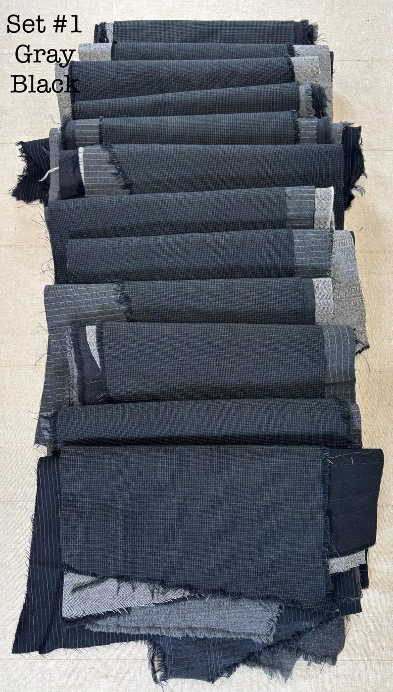 May include: A stack of fabric swatches in various shades of gray and black. The swatches are layered, with some showing a textured weave and others a striped pattern. The text "Set #1 Gray Black" is visible in the upper left corner.