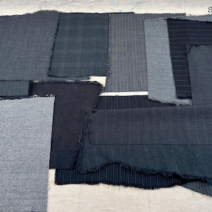 May include: A collection of gray and black fabric swatches with frayed edges. The swatches vary in texture and pattern, including solid, striped, and plaid designs. The text "Set #1 Gray/Black" is visible in the upper right corner.