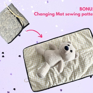 May include: A folded fabric square with a black and white floral pattern tied with a gold ribbon, and a rectangular changing mat with a yellow and white grid pattern featuring a plush teddy bear, with text reading BONUS: Changing Mat sewing pattern.