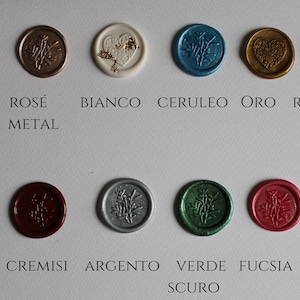 Könnte beinhalten: Eine Auswahl an farbigen Wachssiegeln in verschiedenen Farbtönen, darunter Rot, Gold und Blau. Jedes Siegel zeigt ein botanisches Design und ist mit seinem Farbnamen beschriftet. Das Bild zeigt eine Vielzahl von Farben und Oberflächen.