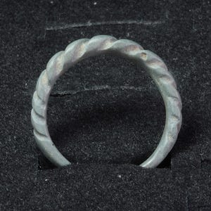 Auténtico anillo retorcido de bronce vikingo antiguo, anillo nórdico antiguo, siglos VIII-X d.C. Hallazgo arqueológico.