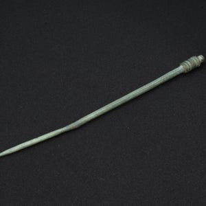 Ancient bronze hairpin with an ornamented head, rare ancient Scythian jewelry from the 5th-2nd centuries BC. Historical artifact Bronze Age.