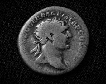 May include: A silver Roman coin with a portrait of a man on one side and Latin text on the other.