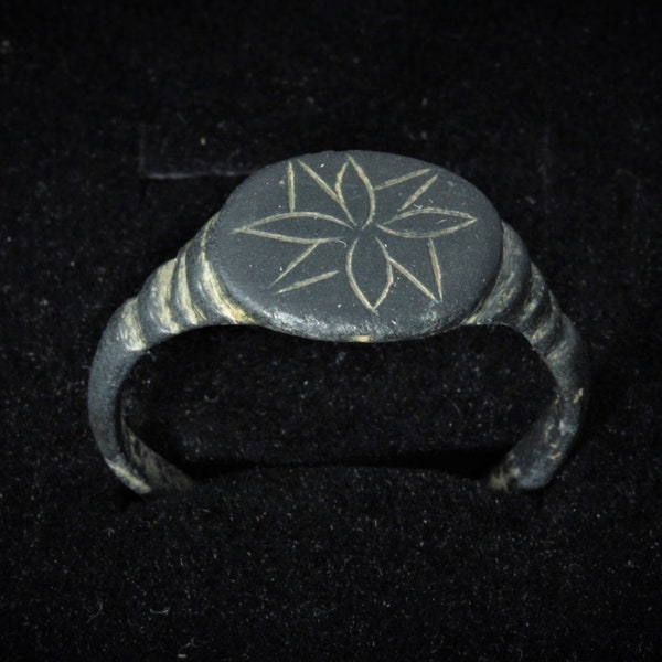 Authentic medieval bronze ring with a stylized lotus flower. The era of the Vikings, 8-12 centuries AD. Archaeological find.