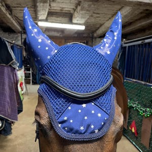 May include: Blue horse fly mask with white stars and a black mesh nose guard.