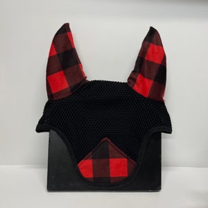May include: Black fly bonnet with red and black buffalo plaid ear covers. The bonnet is made of mesh and has a black trim.