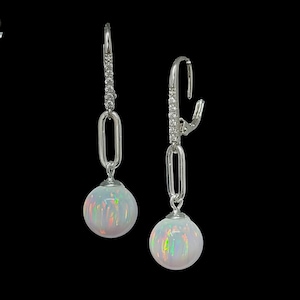 May include: A pair of silver dangle earrings with a white opal gemstone on each earring. The earrings have a chain link design with small clear stones.