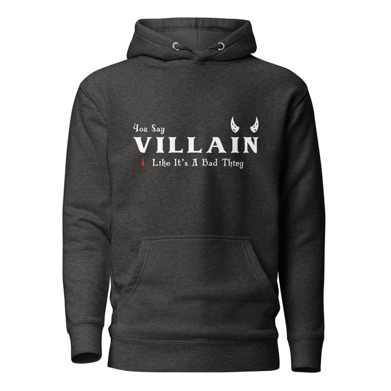 A heather black You Say Villain Like Its A Bad Thing hoodie with cute devil horns created by graphic apparel company Midnight Gypsy Designs as part of their Dark Academia clothing and Bookish Merch clothing line.