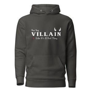 A grey You Say Villain Like Its A Bad Thing hoodie with cute devil horns created by graphic apparel company Midnight Gypsy Designs as part of their Dark Academia clothing and Bookish Merch clothing line.